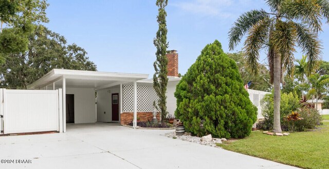 view of front of house with a front yard and a carport