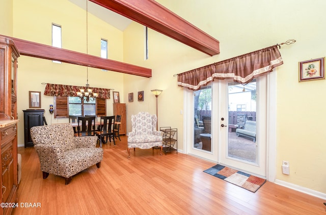 living room featuring a chandelier, beam ceiling, light wood-type flooring, and high vaulted ceiling