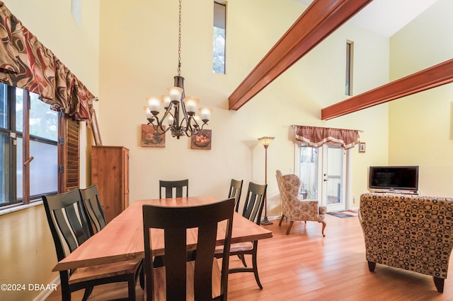 dining space featuring high vaulted ceiling, plenty of natural light, a notable chandelier, and light hardwood / wood-style flooring