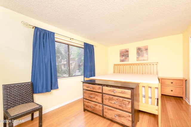 bedroom featuring light wood-type flooring and a textured ceiling