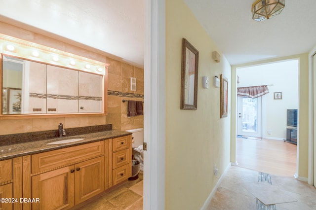 bathroom featuring vanity and tile walls