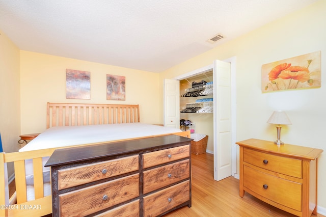 bedroom with light hardwood / wood-style flooring and a closet