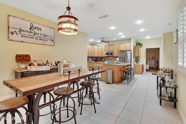 dining space with ceiling fan and light tile patterned floors