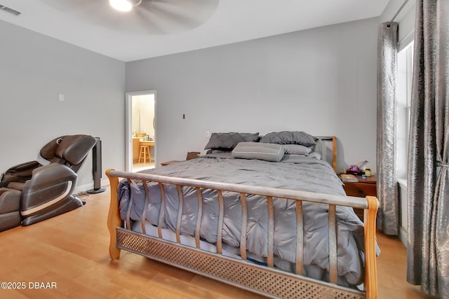 bedroom featuring ceiling fan, hardwood / wood-style floors, and ensuite bathroom