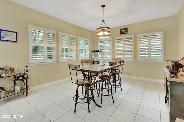 tiled dining space with a chandelier