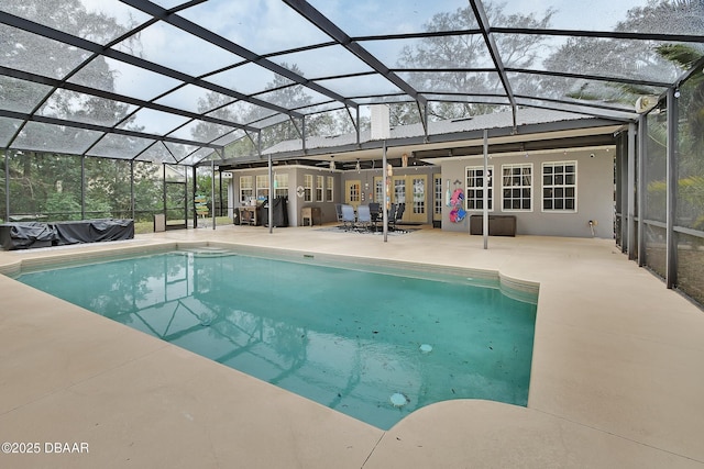 view of pool with glass enclosure, a patio area, and french doors