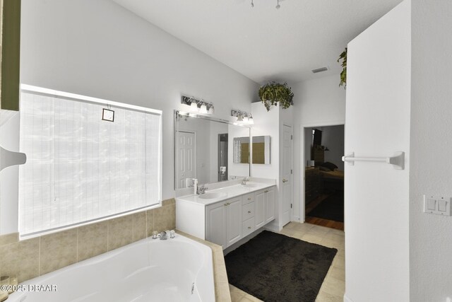 bathroom with tile patterned flooring, vanity, and a bathing tub