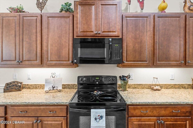 kitchen featuring black appliances and light stone countertops