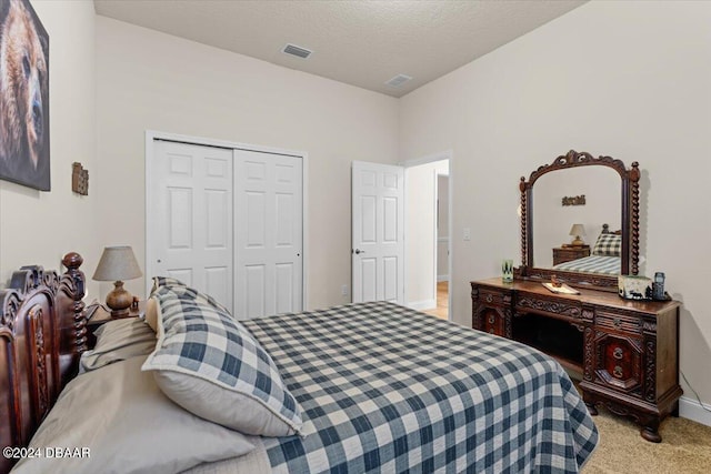 bedroom featuring light colored carpet, a textured ceiling, and a closet