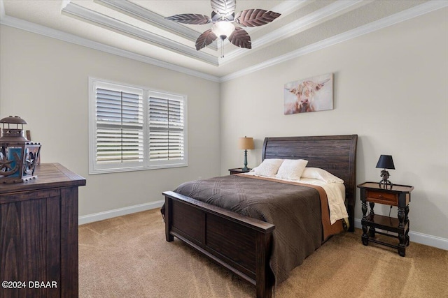 carpeted bedroom featuring ornamental molding, ceiling fan, and a tray ceiling