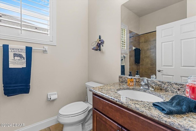 bathroom featuring tile patterned flooring, vanity, toilet, and a tile shower