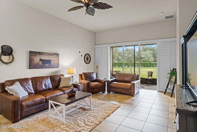 living room featuring lofted ceiling, light tile patterned floors, and ceiling fan