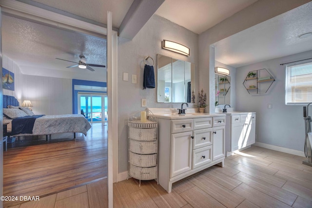 bathroom with ceiling fan, vanity, and a textured ceiling