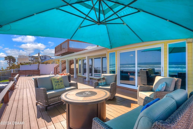 wooden deck featuring an outdoor living space with a fire pit