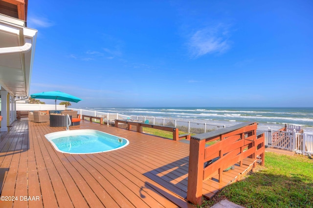 wooden terrace featuring a pool, a water view, and a view of the beach