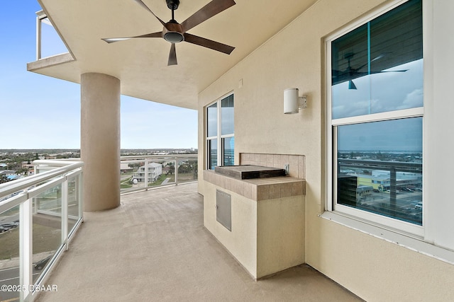 view of patio featuring ceiling fan, a balcony, and beverage cooler