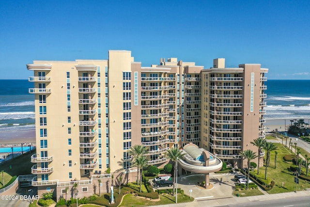 view of building exterior featuring a beach view and a water view