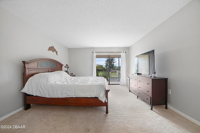 bedroom featuring a textured ceiling, light colored carpet, and access to exterior