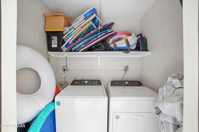 clothes washing area with independent washer and dryer and a textured ceiling