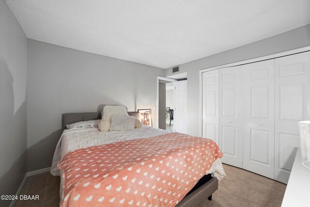 bedroom featuring a closet, carpet, and a textured ceiling