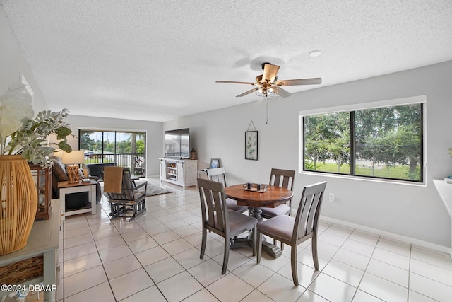 dining space with ceiling fan, a textured ceiling, and light tile patterned floors