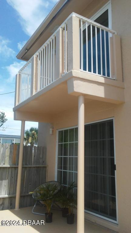 3600 S Peninsula Dr Unit 13, Port Orange, FL 32127 - view of side of home featuring a balcony, stucco siding, and a patio area