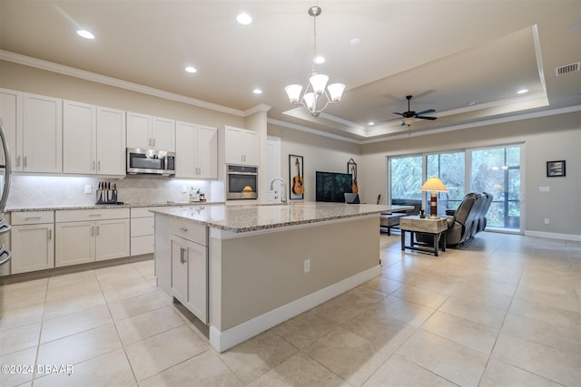 kitchen with pendant lighting, white cabinets, a kitchen island with sink, and appliances with stainless steel finishes