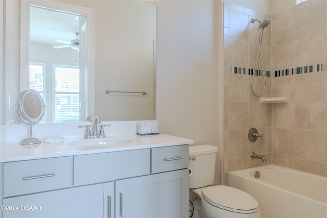 full bathroom with vanity, ceiling fan, tiled shower / bath, and toilet