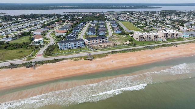 birds eye view of property featuring a beach view and a water view