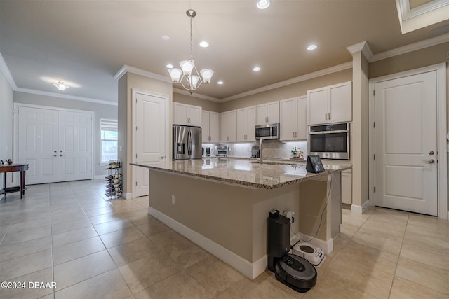 kitchen with white cabinetry, appliances with stainless steel finishes, a center island, and crown molding