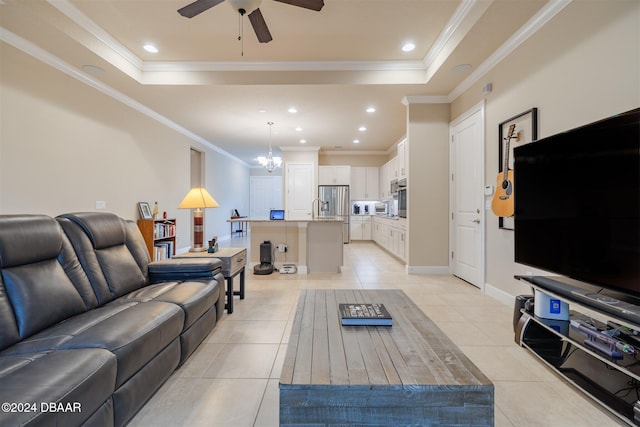 tiled living room featuring ceiling fan with notable chandelier, a raised ceiling, and crown molding