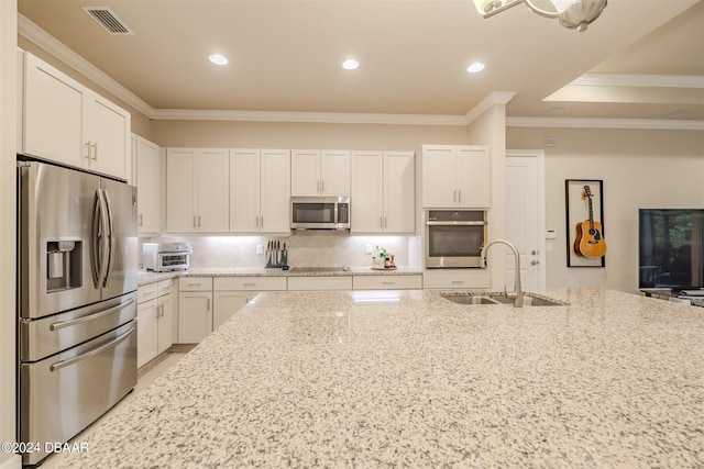 kitchen with white cabinets, sink, ornamental molding, and stainless steel appliances