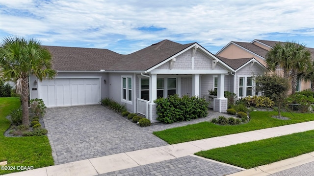 view of front of property featuring a garage, central AC unit, and a front lawn