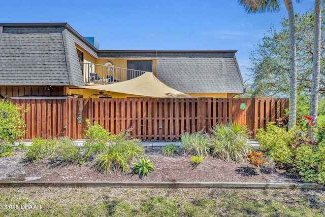 view of yard with a balcony and fence