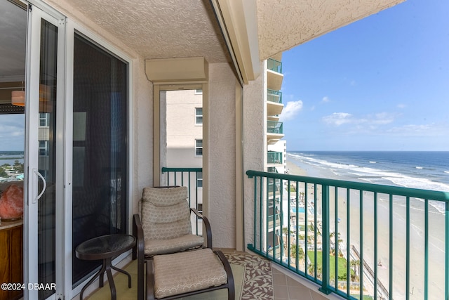 balcony with a water view and a beach view