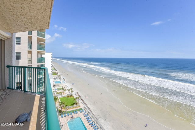 balcony featuring a water view and a beach view