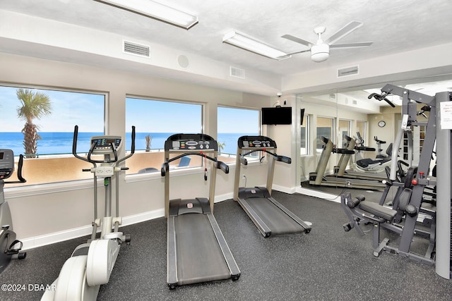 gym featuring a water view and ceiling fan