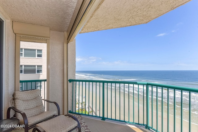 balcony with a water view and a beach view