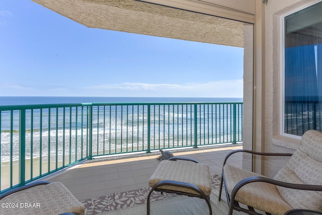 balcony featuring a beach view and a water view