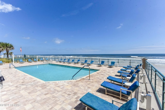 view of pool featuring a water view and a patio area