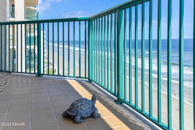 balcony featuring a water view and a beach view