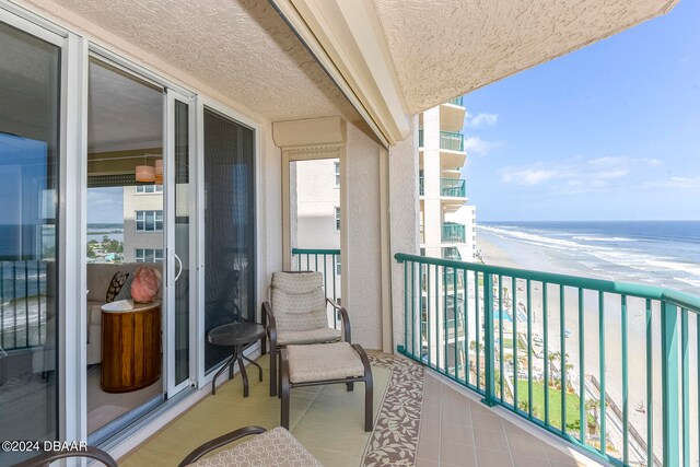 balcony with a water view and a beach view