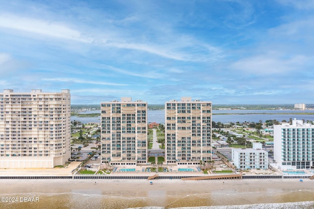 view of building exterior with a beach view and a water view