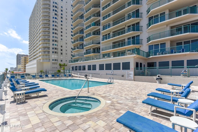 view of swimming pool featuring a patio and a hot tub