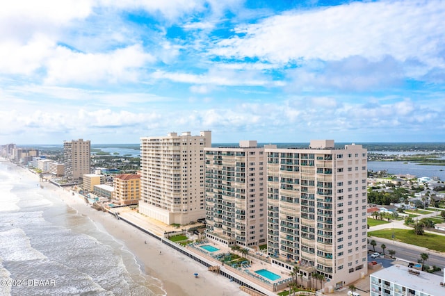 birds eye view of property with a water view and a beach view