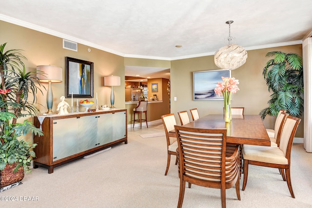 dining area featuring light colored carpet, crown molding, and an inviting chandelier