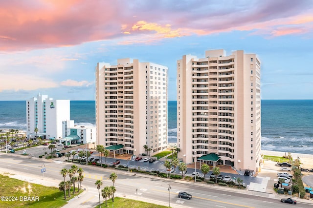 outdoor building at dusk featuring a water view and a view of the beach