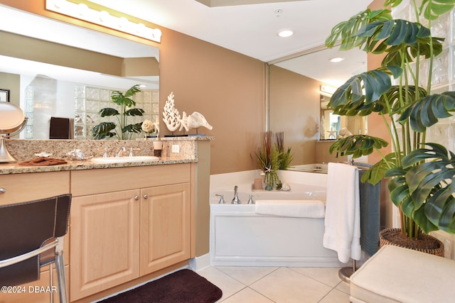 bathroom with a bath, tile patterned flooring, and vanity