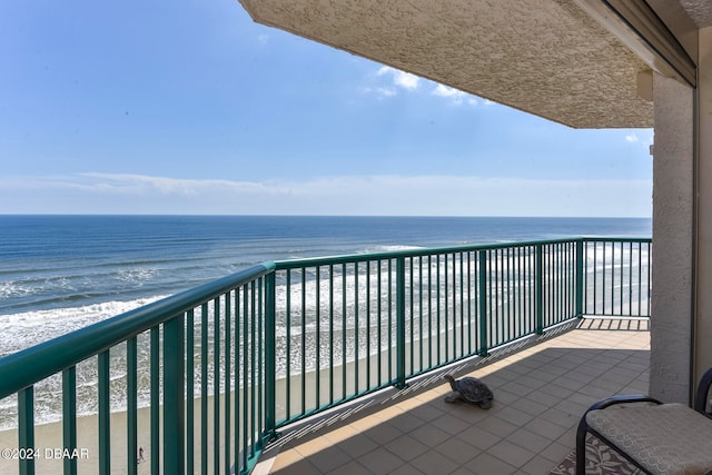 balcony featuring a view of the beach and a water view