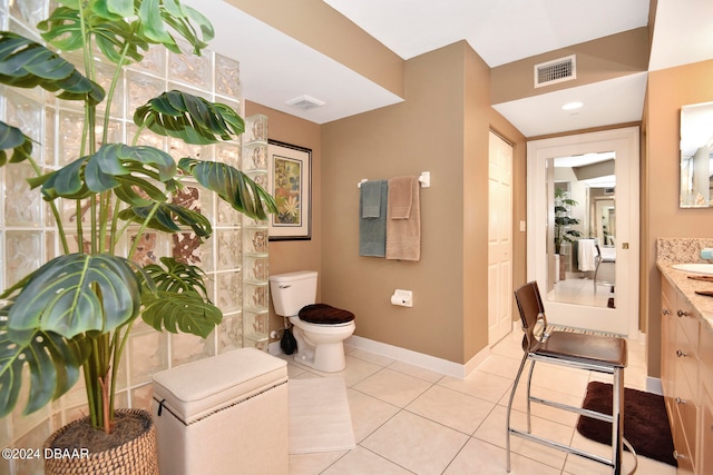 bathroom featuring vanity, tile patterned flooring, and toilet